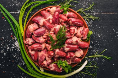 Çiğ tavuk kupa rosemary ile yemek pişirmek için hazır plaka üzerinde ve üzerinde baharat siyah ahşap arka plan. Üstten Görünüm. Metin için boş alan.