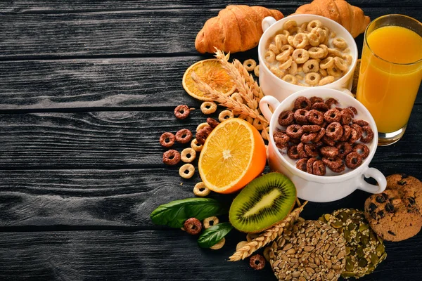 Fitness breakfast, muesli, milk, fruits, nuts and seeds, on a wooden surface. Top view. Free space for text.