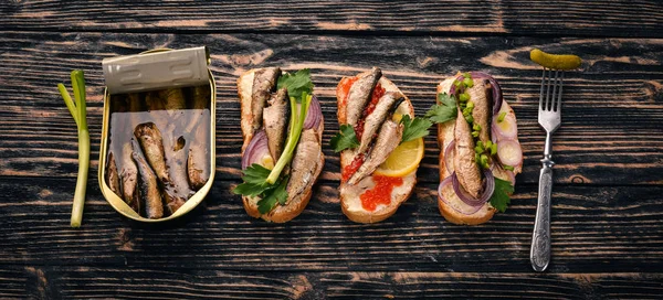 一组三明治与鲱 鱼子酱 洋葱和欧芹 在一个木制的背景 顶部视图 复制空间 — 图库照片