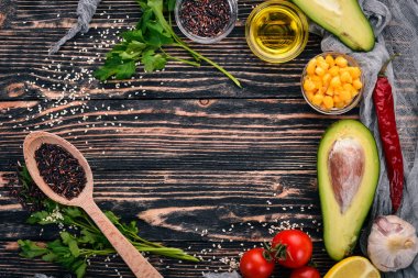 Yemek pişirmek için hazırlık. Avokado, domates, yeşil bezelye ve fındık. Ahşap bir arka plan üzerinde. Üstten Görünüm. Metniniz için boş alan.