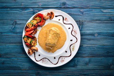 Eti biftek sosu ve ızgara sebzeler. Biftek Voronov. Ahşap bir arka plan üzerinde. Metniniz için boş alan. Üstten Görünüm.