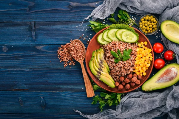 健康食品 アボカド キュウリ トウモロコシ ヘーゼル ナッツ 木製の背景 平面図です テキストの無料スペース — ストック写真
