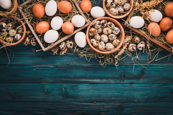 A set of chicken and quail eggs. On a wooden background. Top view. Copy space.