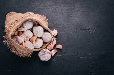 Eski bez torba sarımsak. Taze sarımsak ahşap arka plan üzerinde. Üstten Görünüm. Metin için boş alan.