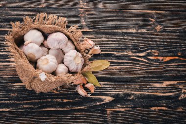 Eski bez torba sarımsak. Taze sarımsak ahşap arka plan üzerinde. Üstten Görünüm. Metin için boş alan.