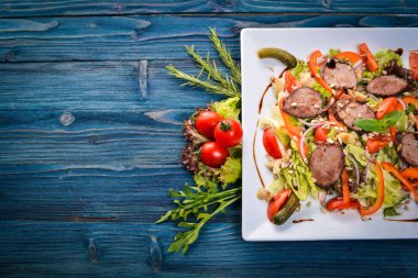 Dana salata, marul ve plaka üzerinde taze sebze. Ahşap bir arka plan üzerinde. Üstten Görünüm. Metin için boş alan.