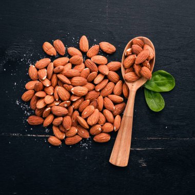 Badem fındık koyu ahşap arka plan üzerinde. Sağlıklı aperatifler. Üstten Görünüm. Metin için boş alan.