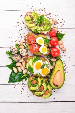 Avokado sandviç, kiraz domates ve bıldırcın yumurtası ve chia tohum kümesi. Ahşap bir arka plan üzerinde. Üstten Görünüm. Metniniz için boş alan.