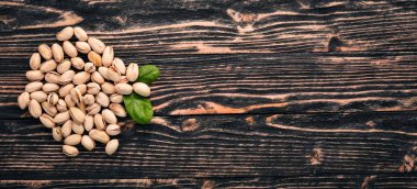 Antep fıstığı koyu ahşap arka plan üzerinde. Sağlıklı aperatifler. Üstten Görünüm. Metin için boş alan.