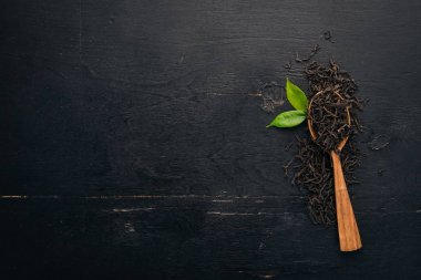 Kuru siyah çay. Ahşap bir arka plan üzerinde. Üstten Görünüm. Kopya alanı.