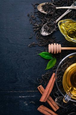 Baharat ve otlar ile cam fincan çay. Siyah ahşap arka plan üzerinde. Üstten Görünüm. Kopya alanı.