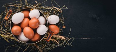 Metal bir tencerede tavuk yumurtası. Ahşap bir arka plan üzerinde. Üstten Görünüm. Kopya alanı.