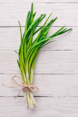 Ahşap arka plan üzerinde taze yeşil soğan. Üstten Görünüm. Metniniz için boş alan.