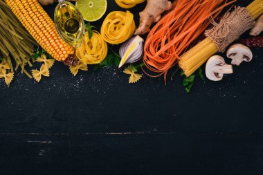 Bir makarna, erişte, makarna, tagliatelle, fettuccine, dizi Farfalle. İtalyan yemek, taze sebze ve baharat. Siyah ahşap arka plan üzerinde. Üstten Görünüm. Kopya alanı.