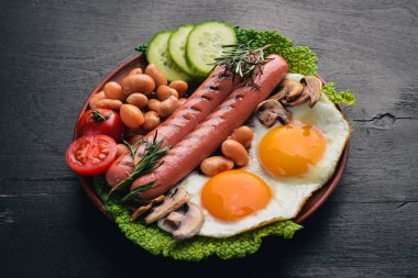 İngiliz kahvaltısı. Kızarmış yumurta, sosis, pastırma, fasulye, tost, domates, kahve fincanı taştan masada. Metin alanı olan Üstten Görünüm