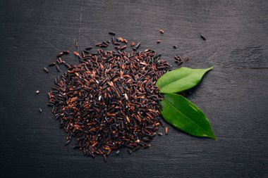 Siyah kuru pirinç. Ahşap bir arka plan üzerinde. Üstten Görünüm. Kopya alanı.