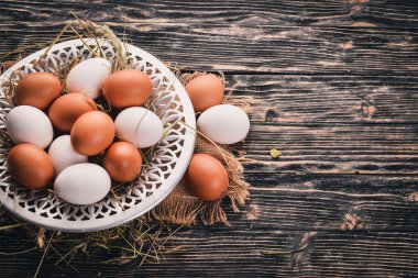 Metal bir plaka üzerinde tavuk çiğ yumurta. Ahşap bir arka plan üzerinde. Üstten Görünüm. Kopya alanı.