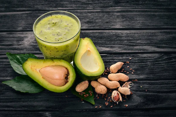 Avocado smoothie and flax seeds and nuts. On a wooden background. Free space for text. Top view.