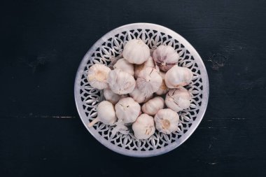 Sarımsak bir plaka üzerinde. Taze sarımsak ahşap arka plan üzerinde. Üstten Görünüm. Kopya alanı.