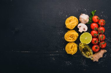 Makarna tagliatelle, ahşap bir zemin üzerine sebzeli fettuccine kuru. Geleneksel İtalyan mutfağı. Üstten Görünüm. Kopya alanı.
