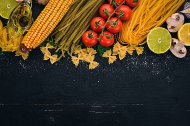 Bir makarna, erişte, makarna, tagliatelle, fettuccine, dizi Farfalle. İtalyan yemek, taze sebze ve baharat. Siyah ahşap arka plan üzerinde. Üstten Görünüm. Kopya alanı.