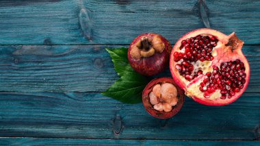 Nar meyve ve mangosteen. Taze tropikal meyve. Ahşap bir arka plan üzerinde. Üstten Görünüm. Kopya alanı.