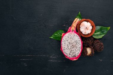 Dragon meyve, rambutan ve mangosteen. Taze tropikal meyve. Ahşap bir arka plan üzerinde. Üstten Görünüm. Kopya alanı.
