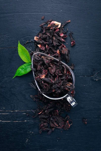 Dry Hibiscus tea. On a wooden background. Top view. Copy space.