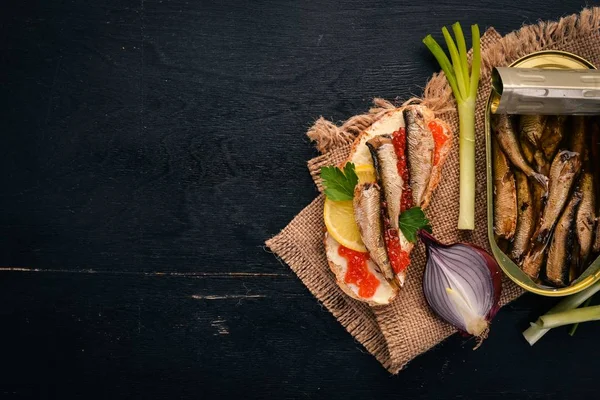 Sandwich with sprats, and caviar, onion, on a wooden background. Top view. Copy space. — Stock Image Sandwich Sprats Caviar Onion Wooden Background Top View Copy Space Royalty Free Stock Images