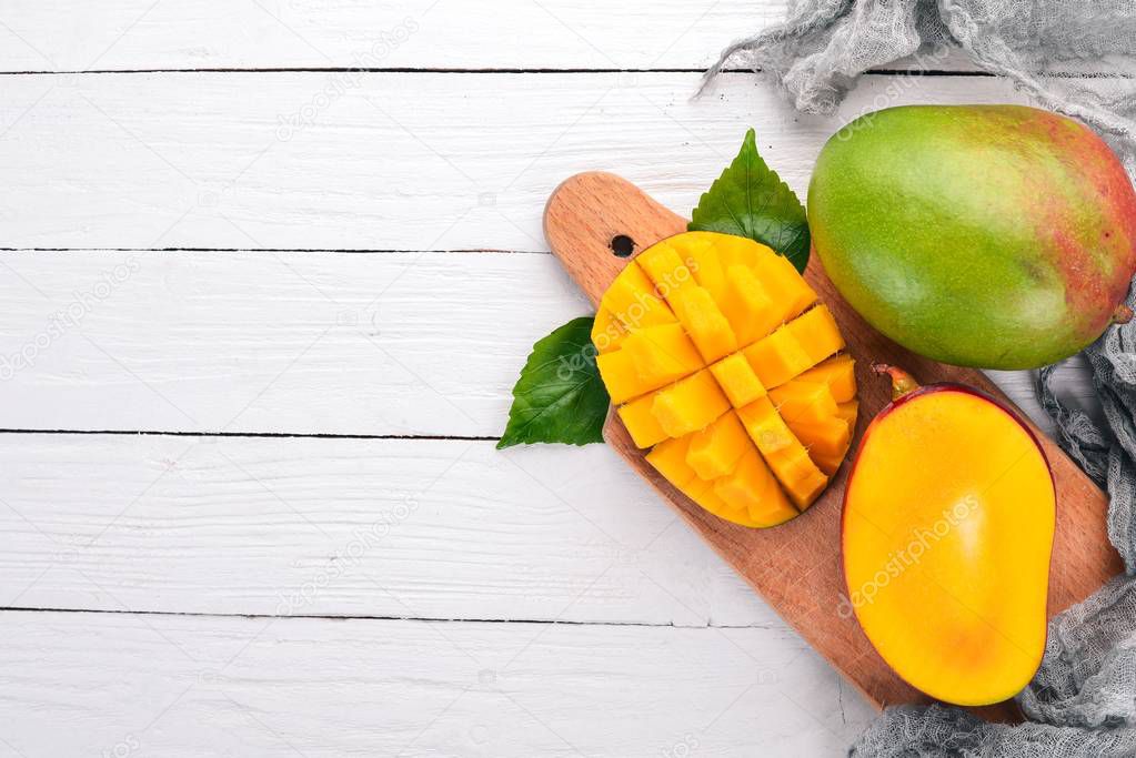 Mango. Tropical Fruits. On a wooden background. Top view. Copy space.