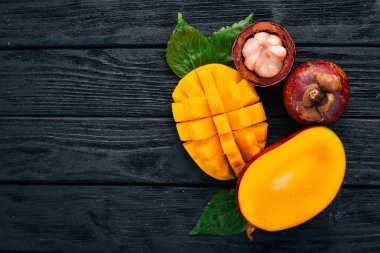 Mango ve mangosteen. Taze tropikal meyve. Ahşap bir arka plan üzerinde. Üstten Görünüm. Kopya alanı.
