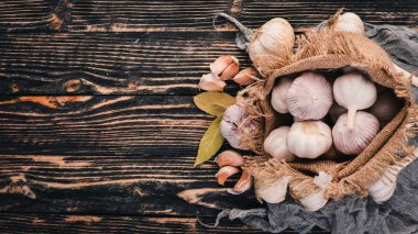Eski bez torba sarımsak. Taze sarımsak ahşap arka plan üzerinde. Üstten Görünüm. Metin için boş alan.