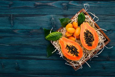 Papaya ve Kamkat. Tropikal meyve. Ahşap bir arka plan üzerinde. Üstten Görünüm. Kopya alanı.
