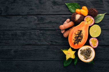 Papaya, Kamkat, granadilla, maracuya, carambola. Tropikal meyve. Ahşap bir arka plan üzerinde. Üstten Görünüm. Kopya alanı.