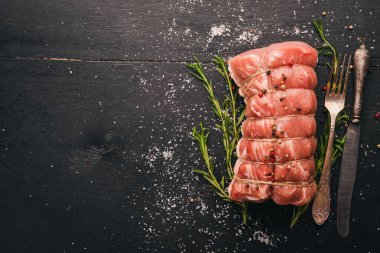Biberiye ve baharat siyah ahşap zemin ile çiğ et sığır filetosu. Üstten Görünüm. Metin için boş alan