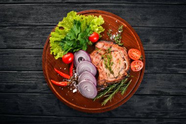 Sebzeli ızgara biftek. Domuz eti, Dana eti, et. Ahşap bir arka plan üzerinde. Üstten Görünüm. Metin için boş alan.