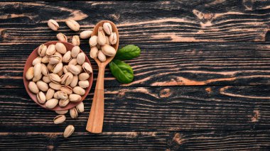 Antep fıstığı koyu ahşap arka plan üzerinde. Sağlıklı aperatifler. Üstten Görünüm. Metin için boş alan.
