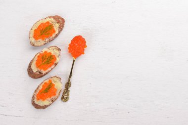 Kırmızı havyar ve tereyağı ile sandviç. Ahşap bir arka plan üzerinde. Üstten Görünüm. Metin için boş alan.