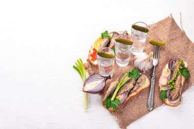 Votka ve sandviç hamsi ve havyar, soğan ve maydanoz, ahşap arka plan üzerinde bir dizi. Üstten Görünüm. Kopya alanı.