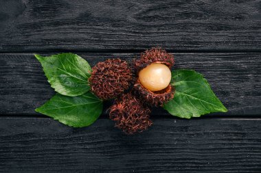 Rambutan tropikal meyve. Ahşap bir arka plan üzerinde. Üstten Görünüm. Kopya alanı.