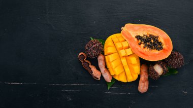 Mango ve Papaya. Tropikal meyve. Ahşap bir arka plan üzerinde. Üstten Görünüm. Kopya alanı.
