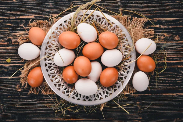 stock image Chicken raw eggs on a metal plate. On a wooden background. Top view. Copy space.