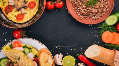 Kahvaltı. Omlet, karabuğday, mantar, fındık, taze sebze. Ahşap bir arka plan üzerinde. Üstten Görünüm. Kopya alanı.