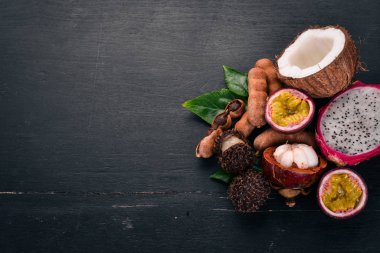 Hindistan cevizi, mangosten, dragon meyve, demirhindi. Taze tropikal meyve. Ahşap bir arka plan üzerinde. Üstten Görünüm. Kopya alanı.