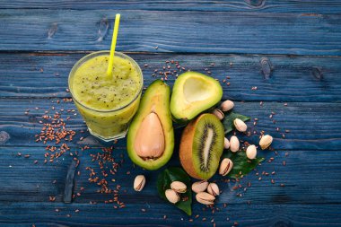 Kivi güler yüzlü ve keten tohumu ve fındık ile avokado. Ahşap bir arka plan üzerinde. Üstten Görünüm. Metniniz için boş alan.