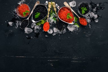 Ahşap arka plan üzerinde siyah ve kırmızı havyar kaşıkla. Üstten Görünüm. Metin için boş alan.