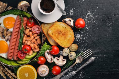 İngiliz kahvaltısı. Kızarmış yumurta, sosis, pastırma, fasulye, tost, domates, kahve fincanı taştan masada. Metin alanı olan Üstten Görünüm
