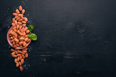 Badem fındık koyu ahşap arka plan üzerinde. Sağlıklı aperatifler. Üstten Görünüm. Metin için boş alan.