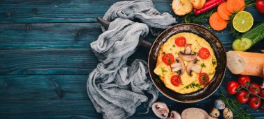 Mantar ve taze sebze ve fındık bir tavada omlet. Ahşap bir arka plan üzerinde. Üstten Görünüm. Kopya alanı.