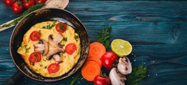 Mantar ve taze sebze ve fındık bir tavada omlet. Ahşap bir arka plan üzerinde. Üstten Görünüm. Kopya alanı.